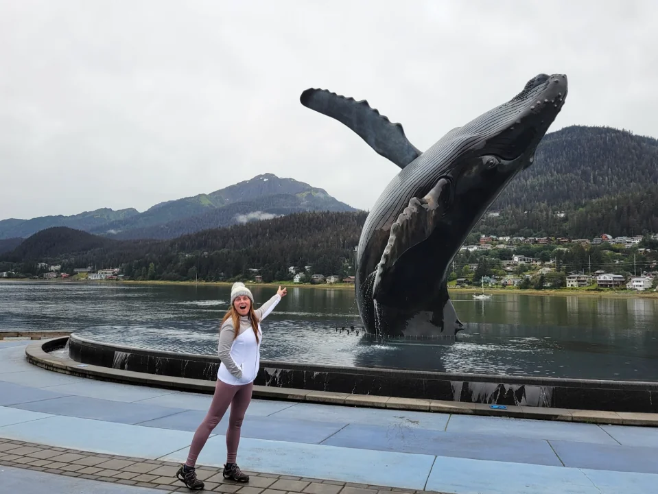 Author Jena Worth beside the Juneau humpback whale statue in Alaska